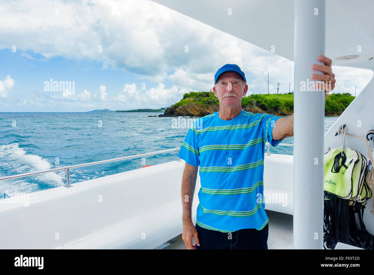 Un 77 ans caucasien homme s'accroche à un poteau sur un catamaran bateau sur la mer des Caraïbes, les Îles Vierges des États-Unis. USVI, U.S.V.I. Banque D'Images