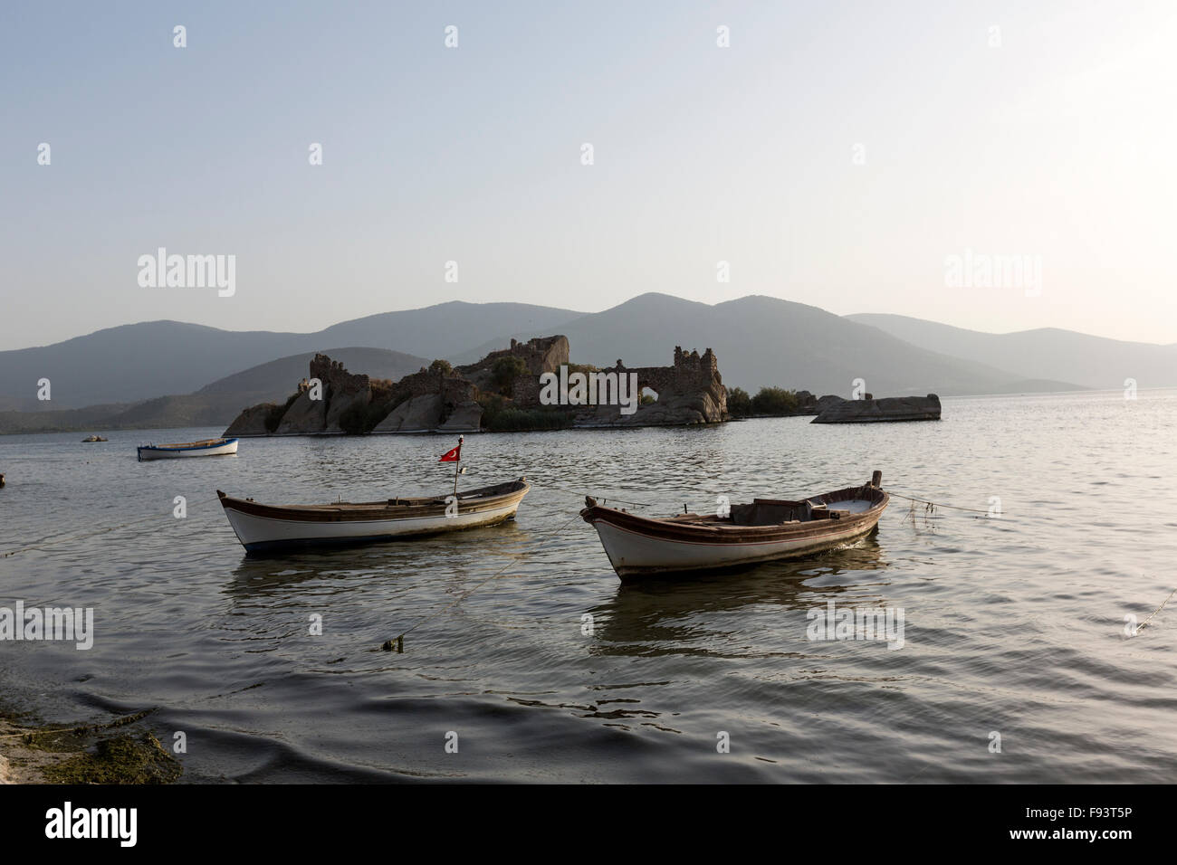 Kapıkırı beach avec les bateaux de pêche dans le lac Bafa et un château dans une petite île rocheuse, Turquie Banque D'Images