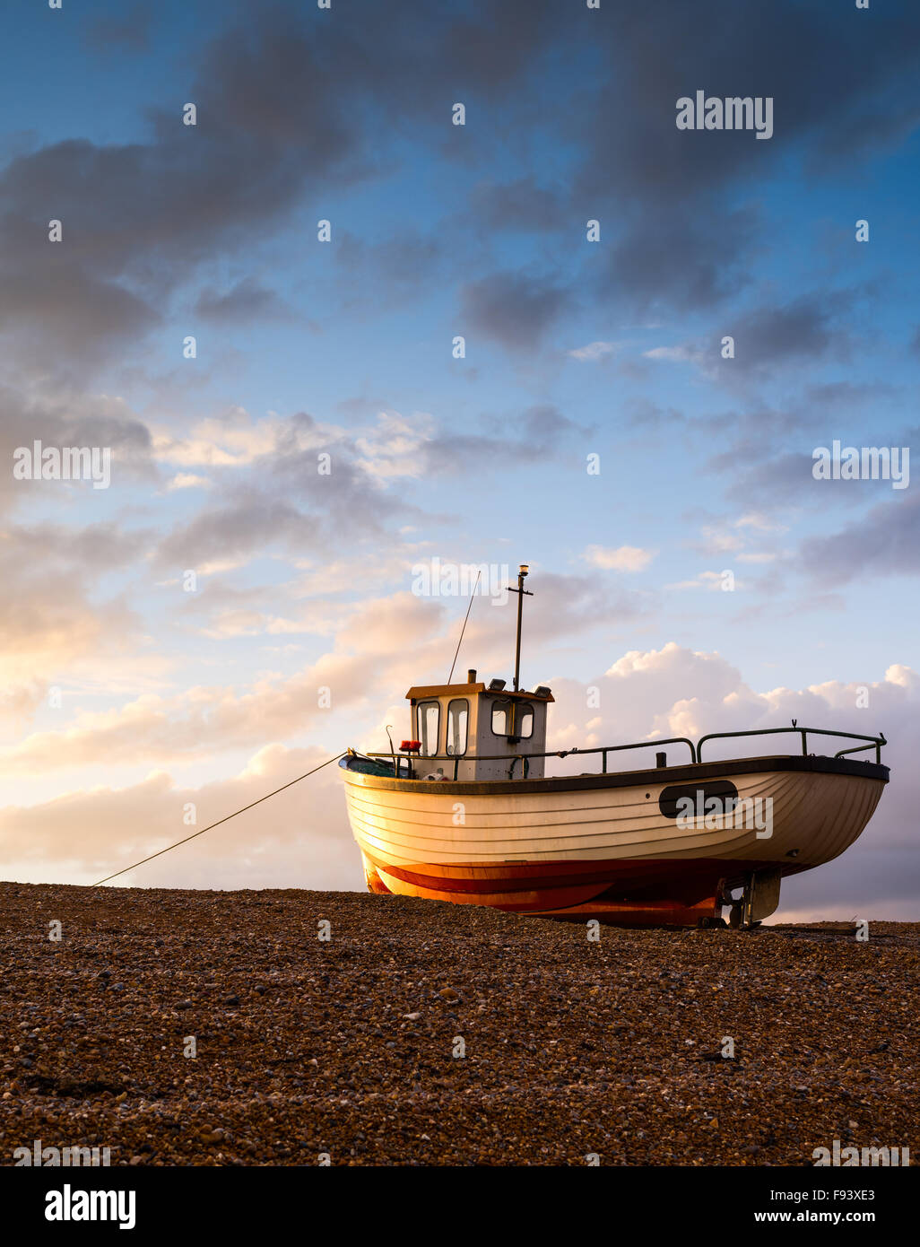 Un seul bateau de pêche attrape la dernière lumière à Dungeness, Kent. Banque D'Images