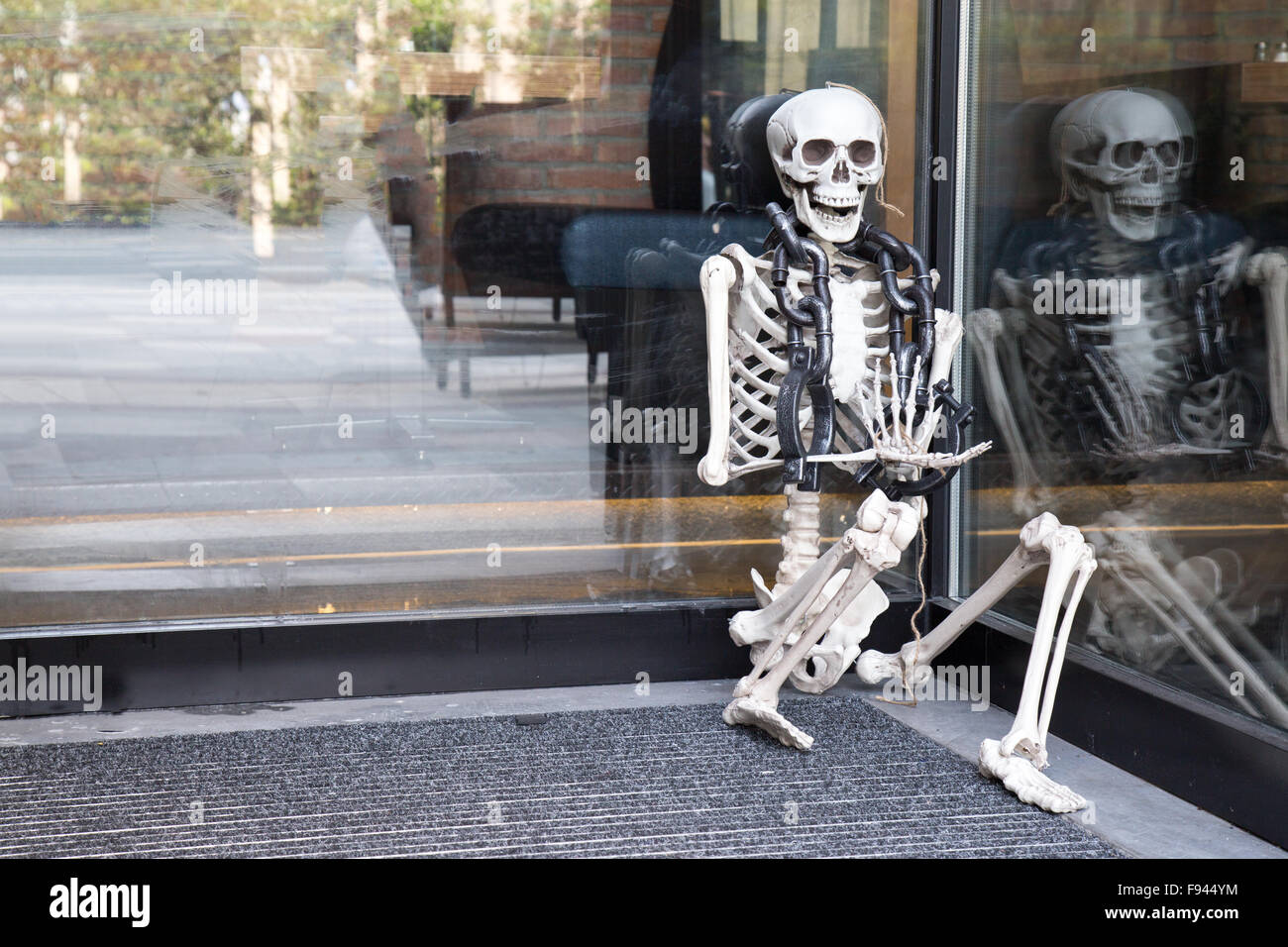 Skelleton en chaînes assis en entrée du restaurant Banque D'Images