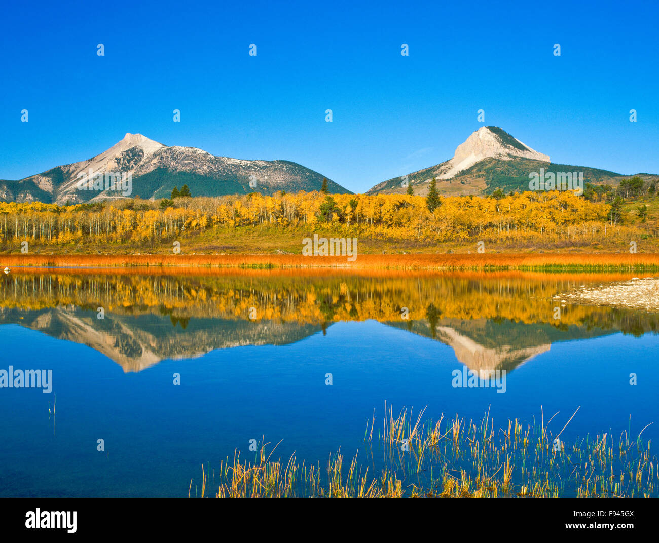 coeur butte et la montagne de plumes se reflète dans un étang le long du front de montagne rocailleux près de coeur butte, montana Banque D'Images