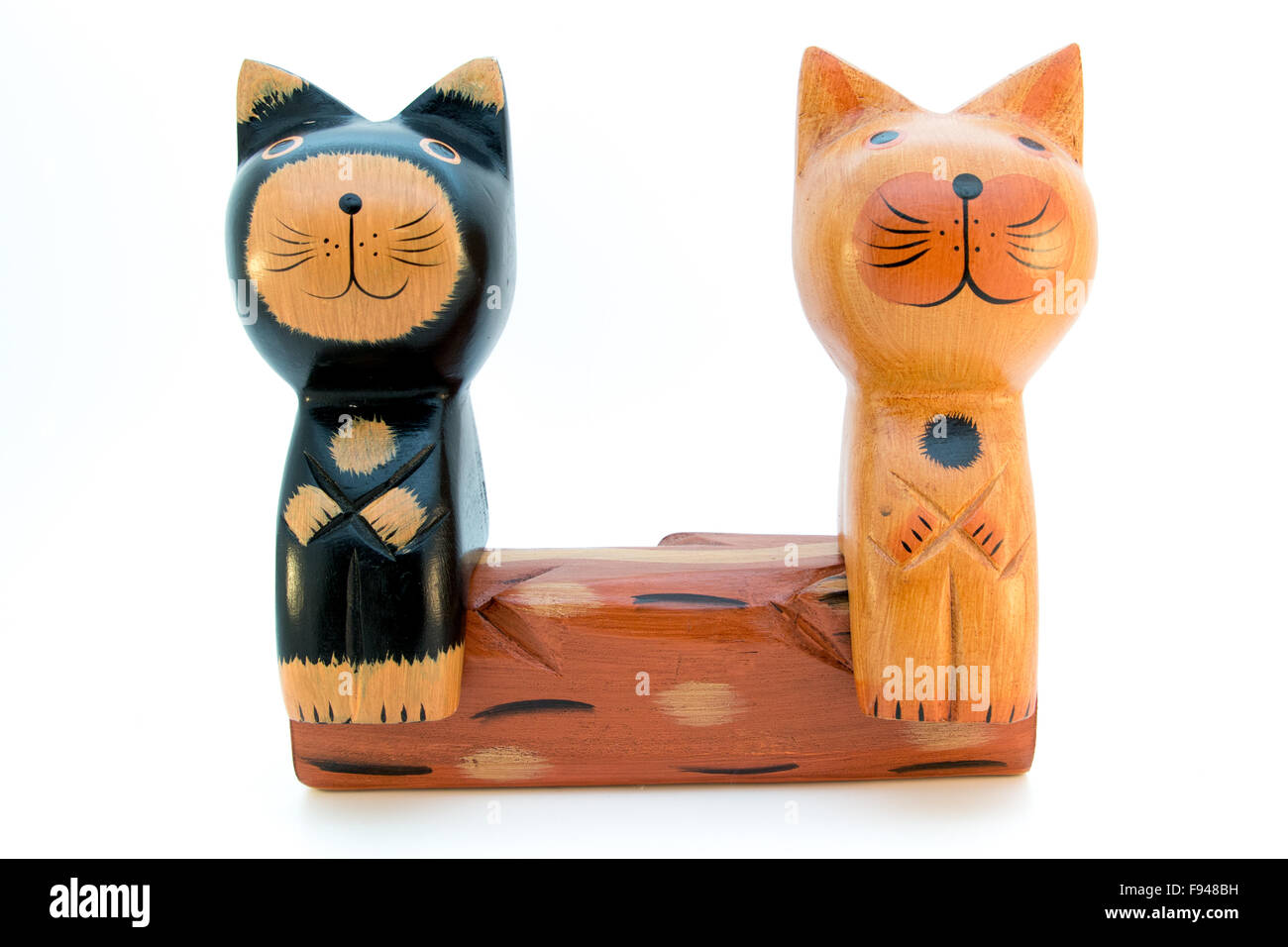 Un noir et un chat en bois brun assis sur un banc à côté de l'autre Banque D'Images