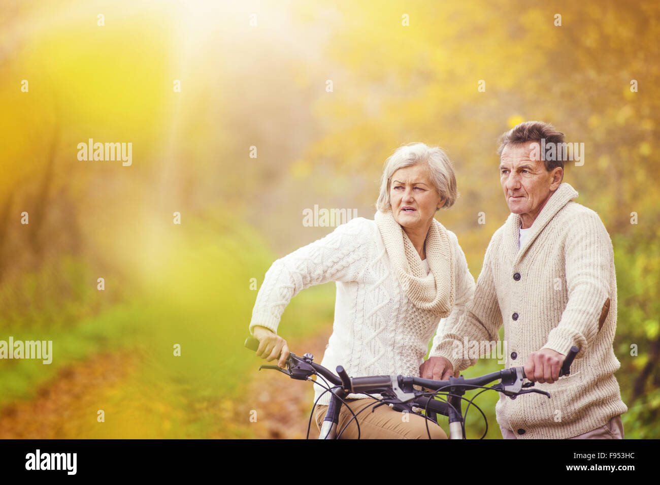 Les aînés actifs riding bike en automne la nature. Ils se détendre à l'extérieur. Banque D'Images