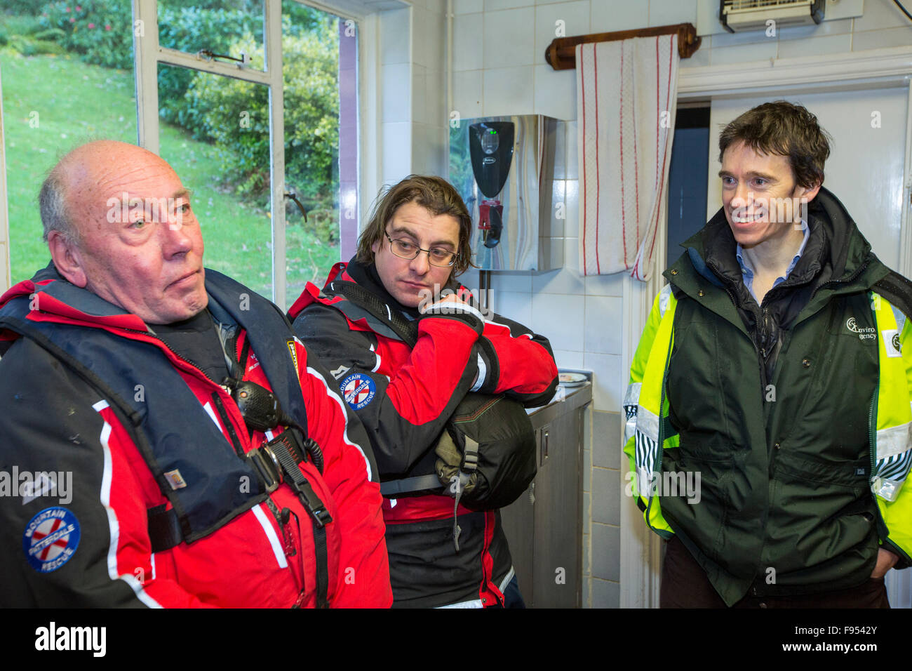 Rory Stewart, sous-secrétaire d'État parlementaire au ministère de l'environnement, de l'Alimentation et des Affaires rurales répond aux membres de l'équipe de sauvetage en montagne de Patterdale qui fournissent des vivres aux victimes des inondations à l'hôtel Howtown, qui ont été coupées par les inondations de Storm Desmond. Photos prises le vendredi 11 décembre 2015 Banque D'Images