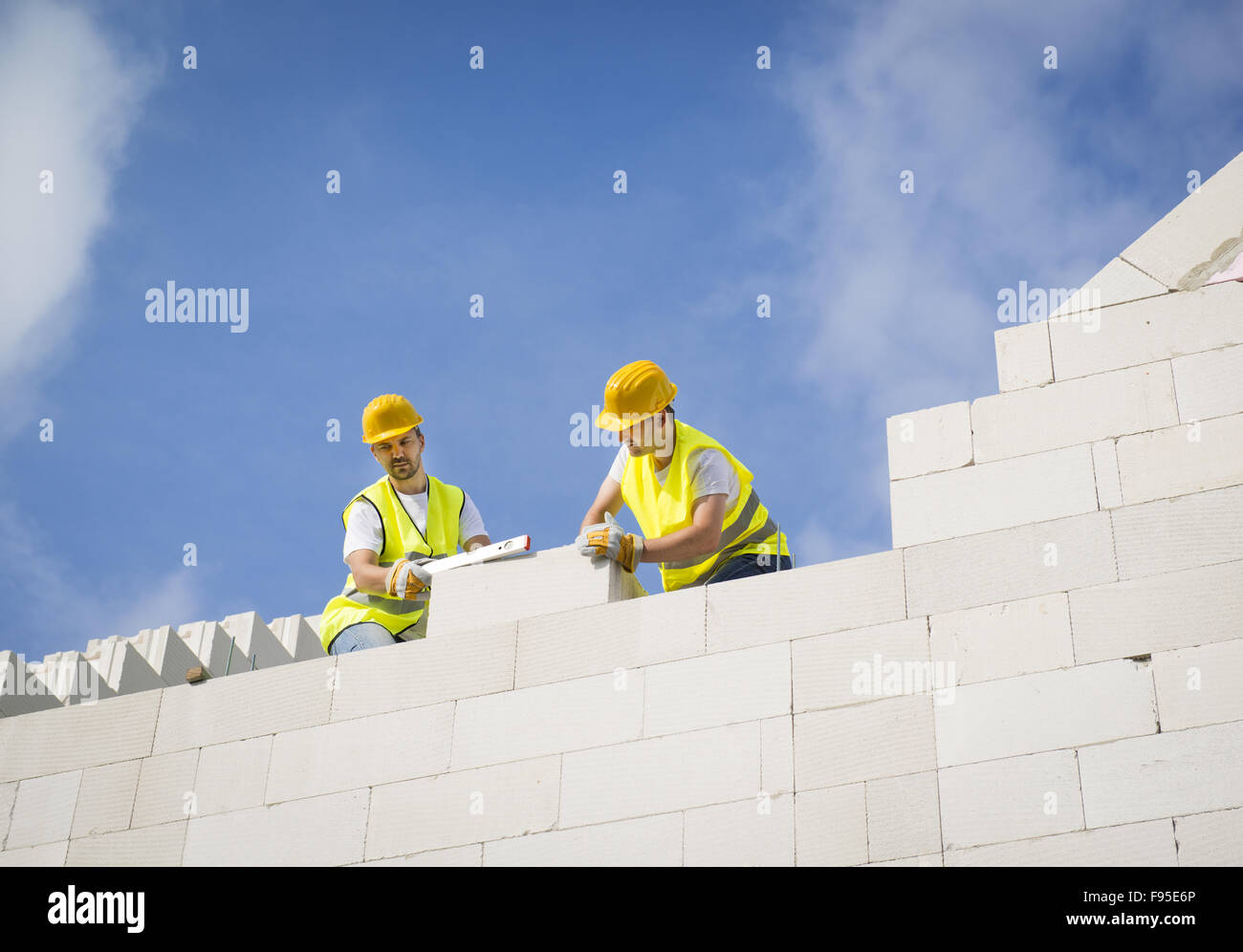 Les constructeurs travaillent sur le haut de la construction de maisons. Banque D'Images