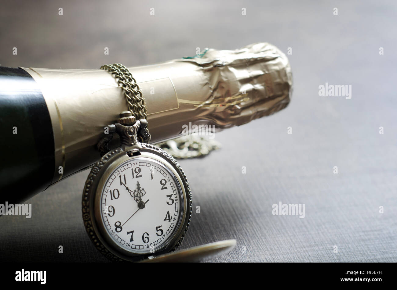 Détail d'une ancienne montre de poche avec chaîne et champange col du  flacon avec les mains de la regarder approcher minuit Photo Stock - Alamy