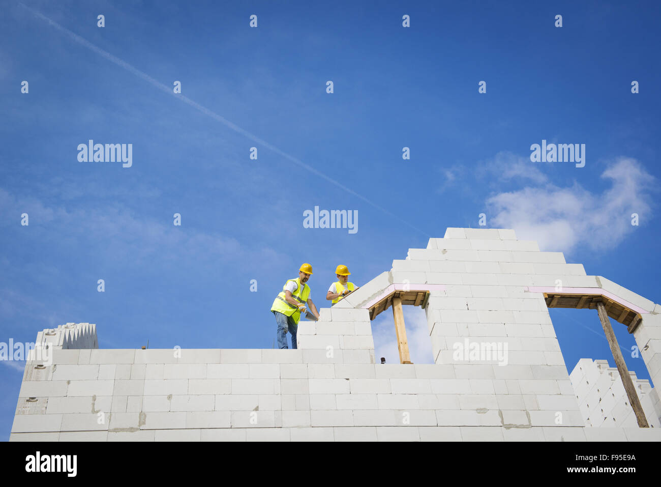 Les constructeurs travaillent sur le haut de la construction de maisons. Banque D'Images