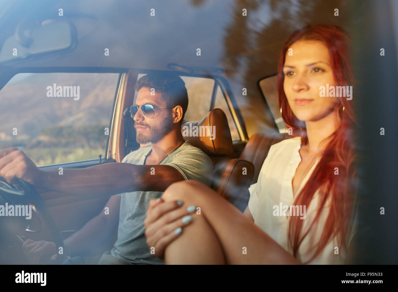 En plein air shot of a young couple on road trip. La conduite de l'homme sont à jour d'été avec sa petite amie. Banque D'Images