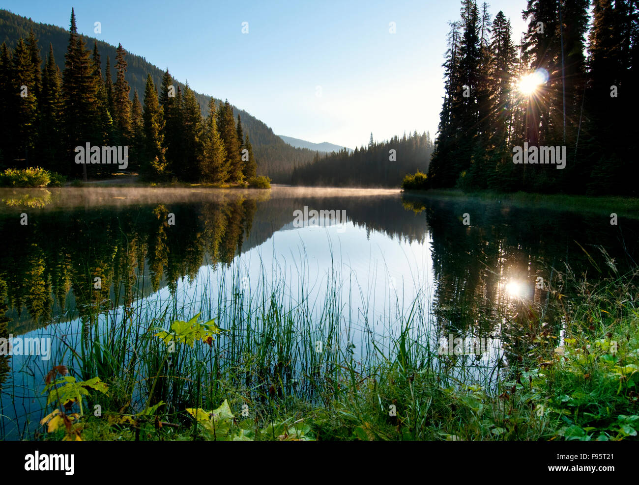 La fin de l'été le soleil se lève sur le lac de la foudre à Manning Park, BC et fournit une réflexion spectaculaire. Banque D'Images