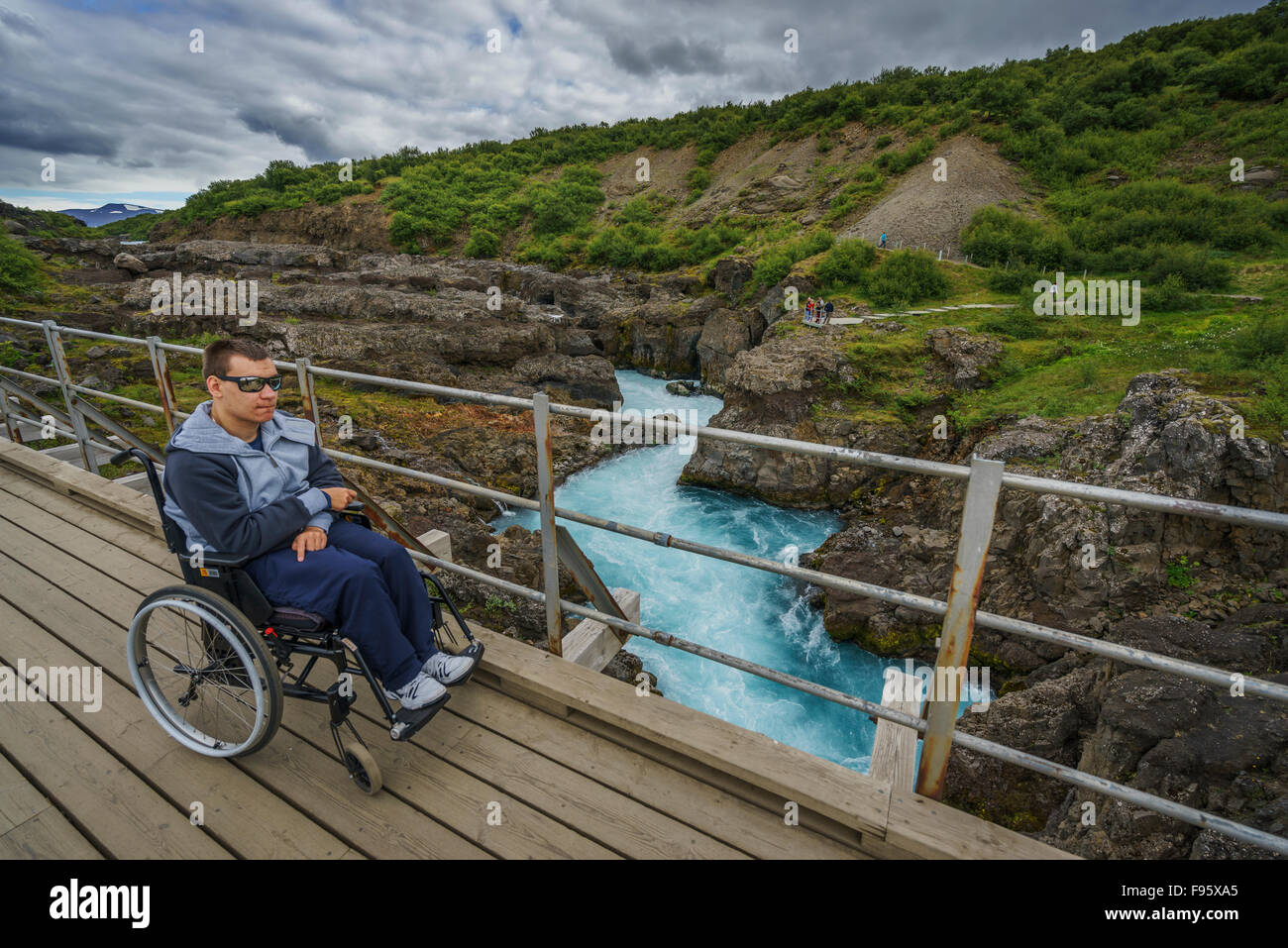 Homme en fauteuil roulant sur l'affichage de la plate-forme, de Borgarfjordur, Islande, Hraunfossar Banque D'Images