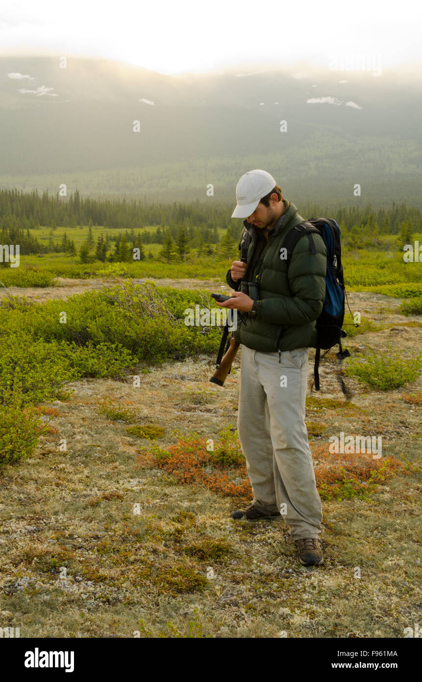 Un chasseur utilise un GPS pour trouver son emplacement dans le caribou du nord-est de la Colombie-Britannique Banque D'Images