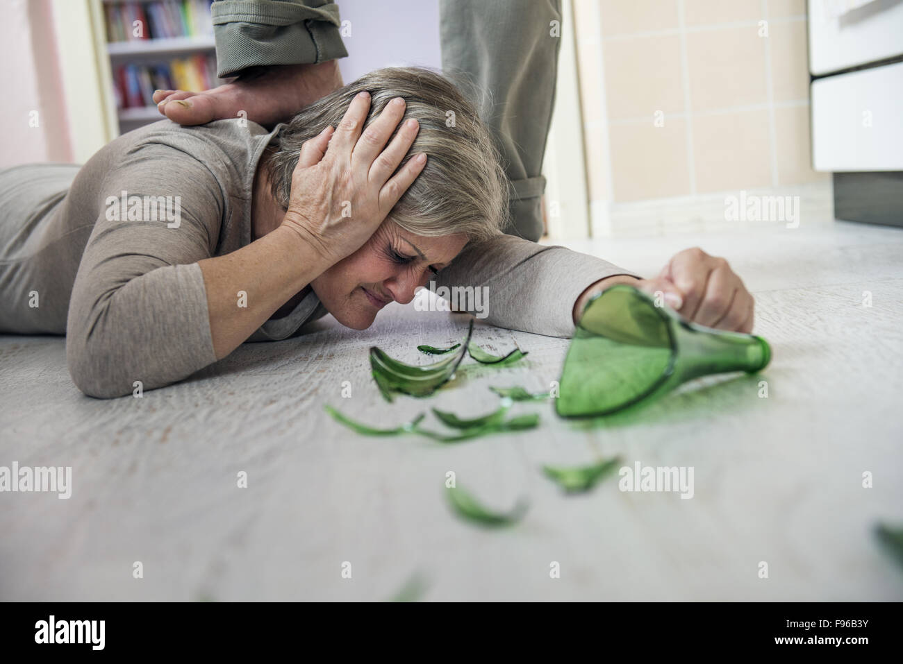 Femme victime de violence domestique et d'abus. Femme mature d'un homme effrayé avec bouteille cassée Banque D'Images