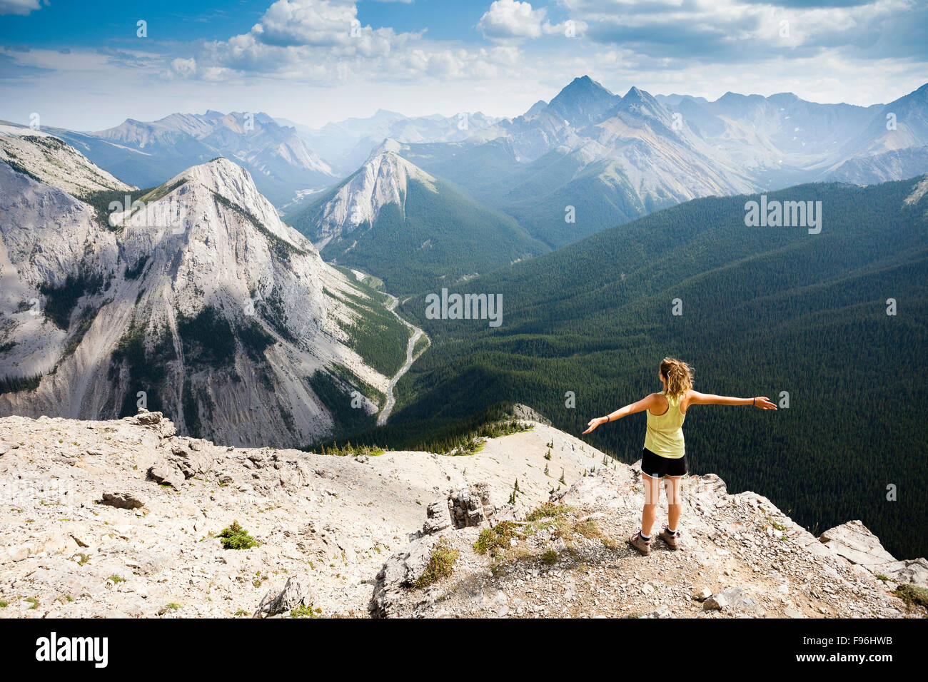 Une jeune femme se tient au sommet de la piste de Sulphur Skyline avec une vue sur les montagnes Rocheuses. Les sources thermales Miette, Jasper Banque D'Images