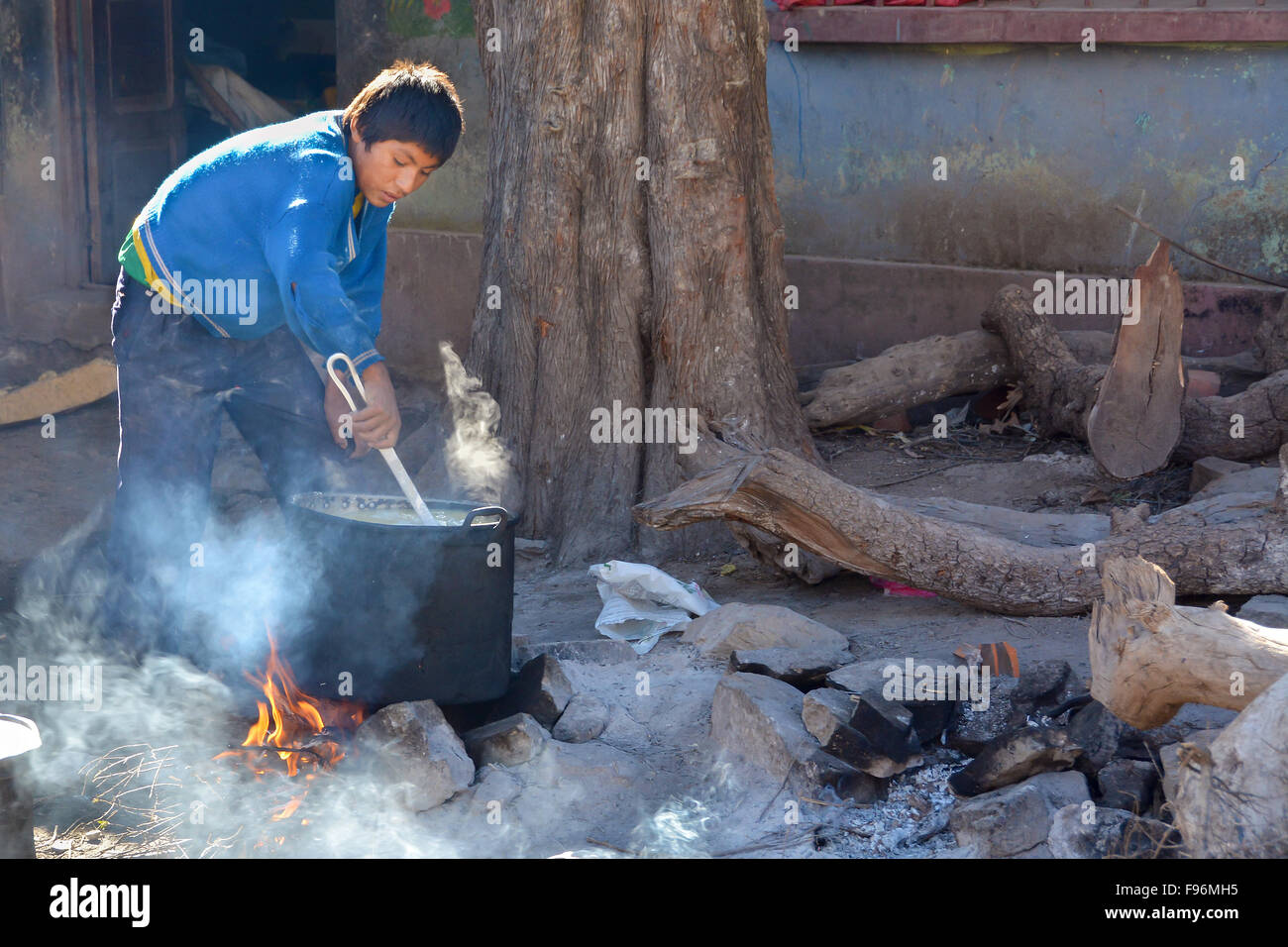 Écolier préparer le petit-déjeuner sur un feu ouvert, un internat à Potosi, Bolivie Banque D'Images