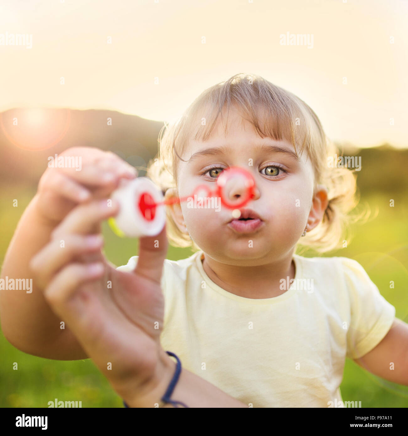 Happy little girl blowing bubbles en été la nature Banque D'Images