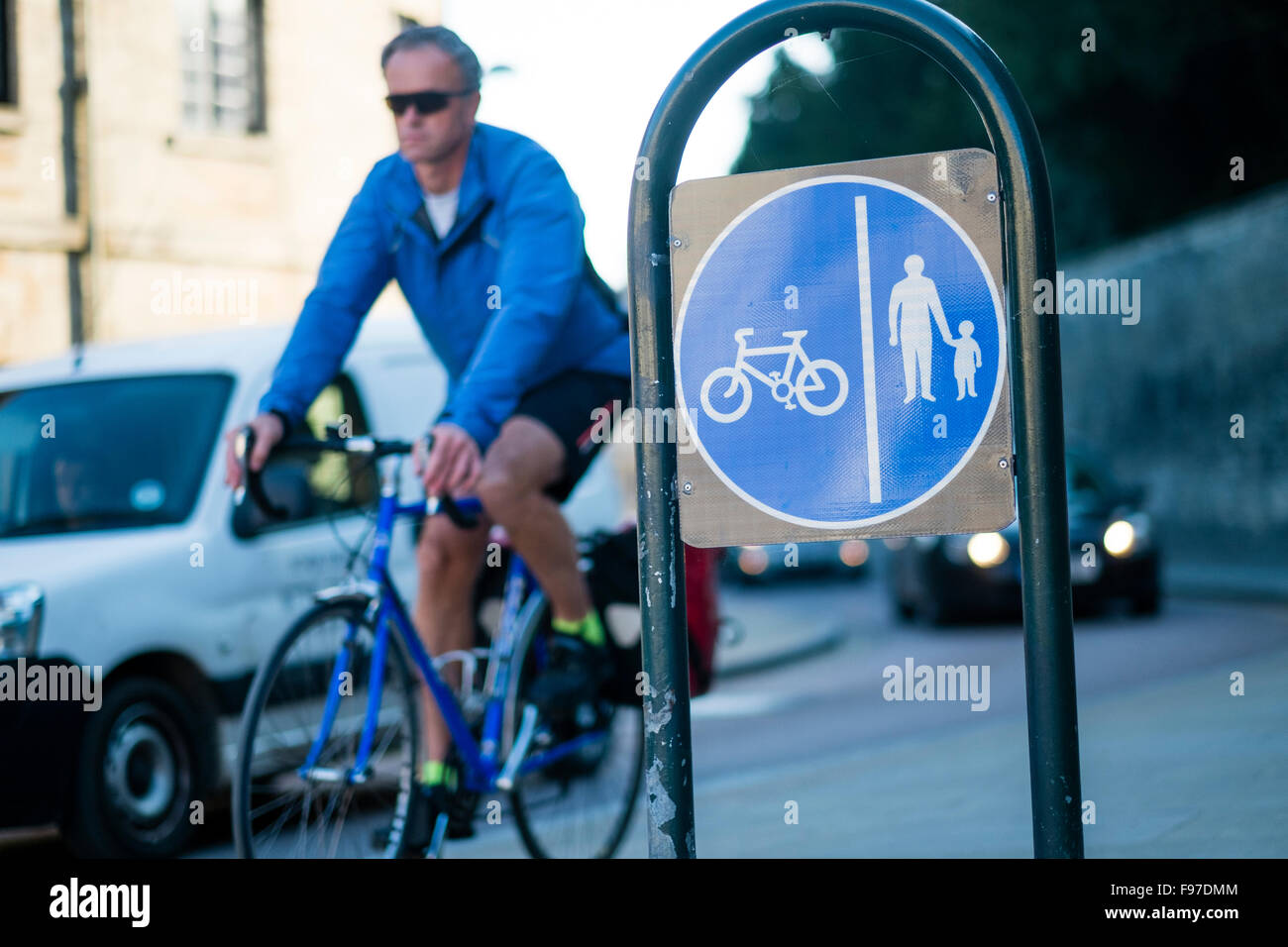 Un homme à vélo poster un signe pour un cycle dédié et piétonnière, Cirencester, Gloucestershire, England, UK Banque D'Images