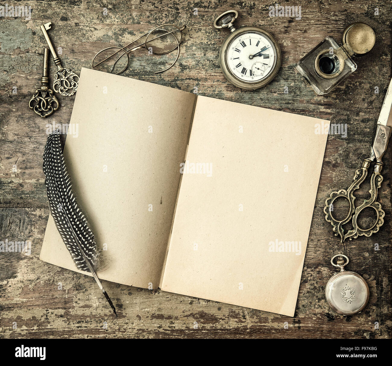 Livre ouvert et vintage les fournitures de bureau sur table en bois. Stylo plume, encrier, touches sur fond texturé. Retro style tonique pict Banque D'Images