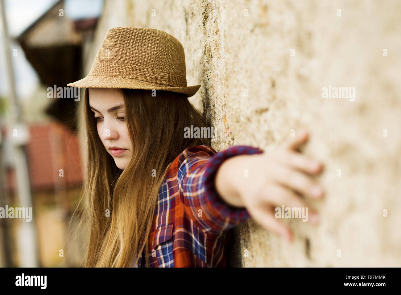 Outdoor portrait of teenage girl in hipster hat posing par l'ancien mur Banque D'Images