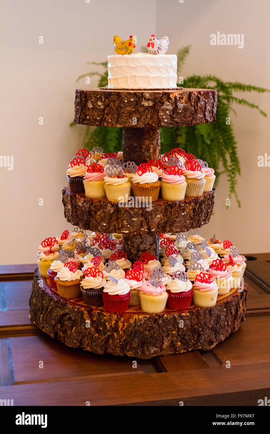 Tour en bois holding réception de mariage cupcakes et un gâteau pour les mariés. Banque D'Images