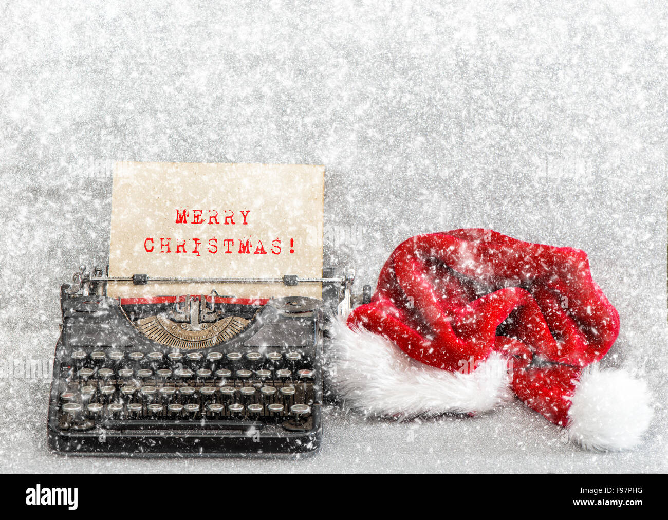 Vieille machine à écrire avec Red Hat et l'exemple de texte Joyeux Noël. Style Retro photo avec effet de chute de neige Banque D'Images