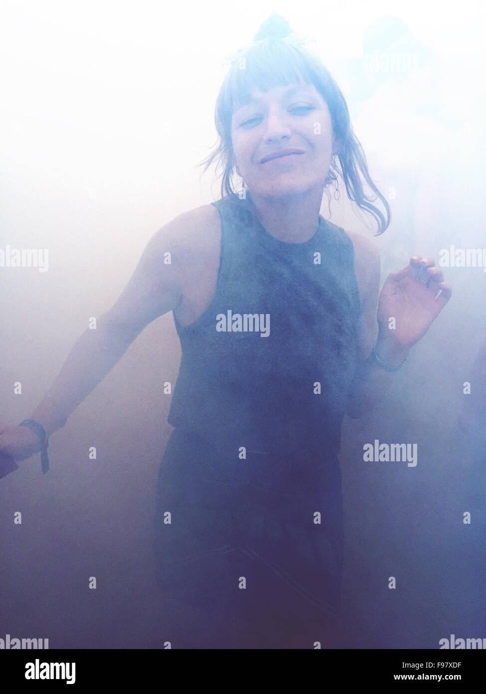 Portrait Of Happy Woman Dancing en fumée Banque D'Images