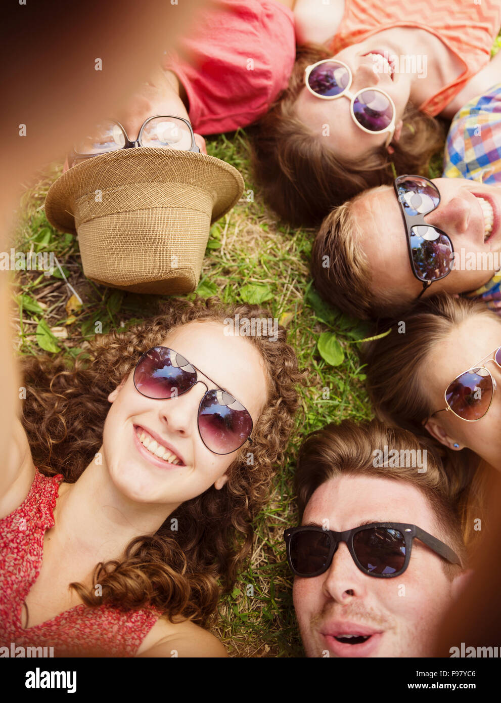 Groupe de jeunes gens s'amuser dans le parc, allongé sur l'herbe Banque D'Images