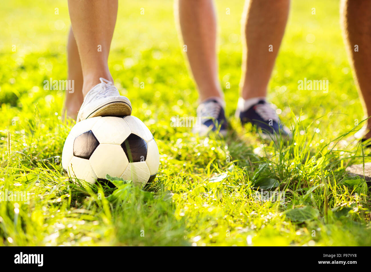 Close up de pieds et balle de football sur la pelouse de l'herbe verte Banque D'Images