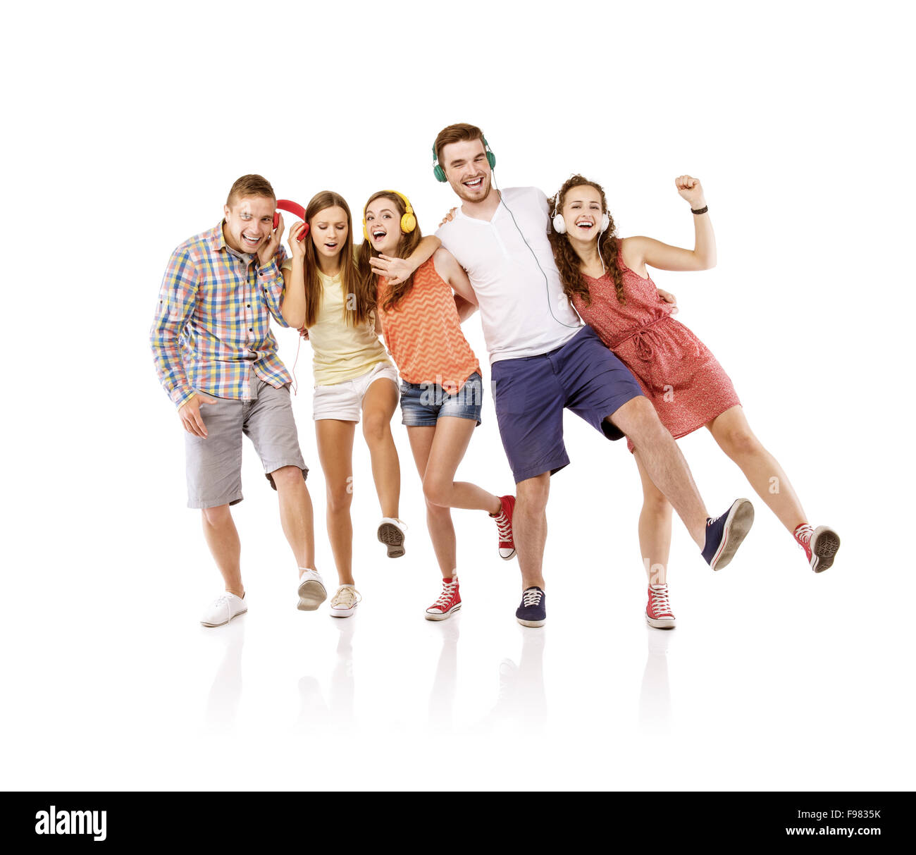 Groupe de jeunes à écouter la musique, isolé sur fond blanc. Banque D'Images