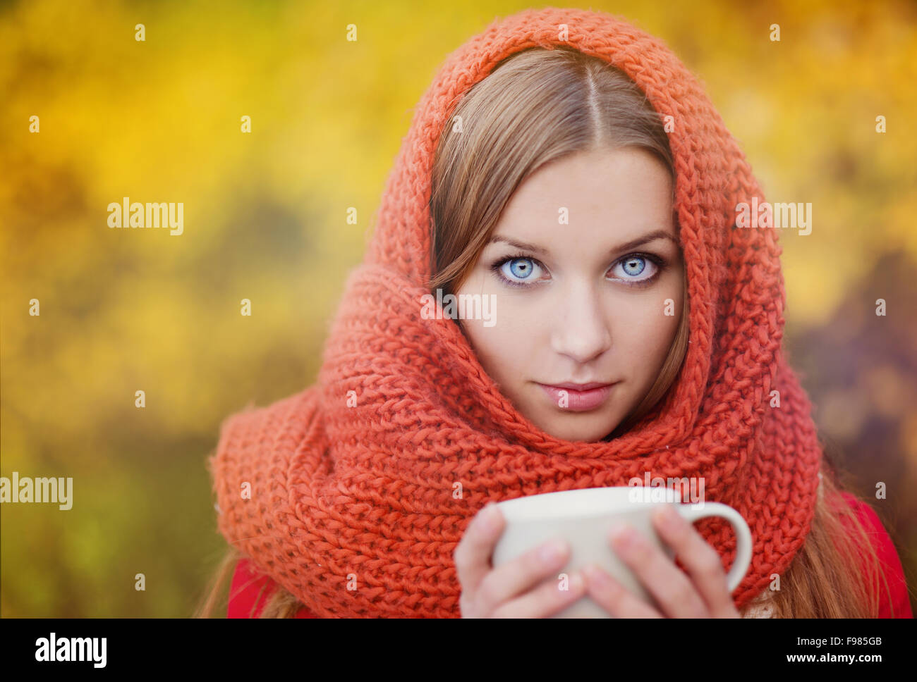 Portrait de belle fille avec foulard et tasse avec boisson chaude en automne nature Banque D'Images