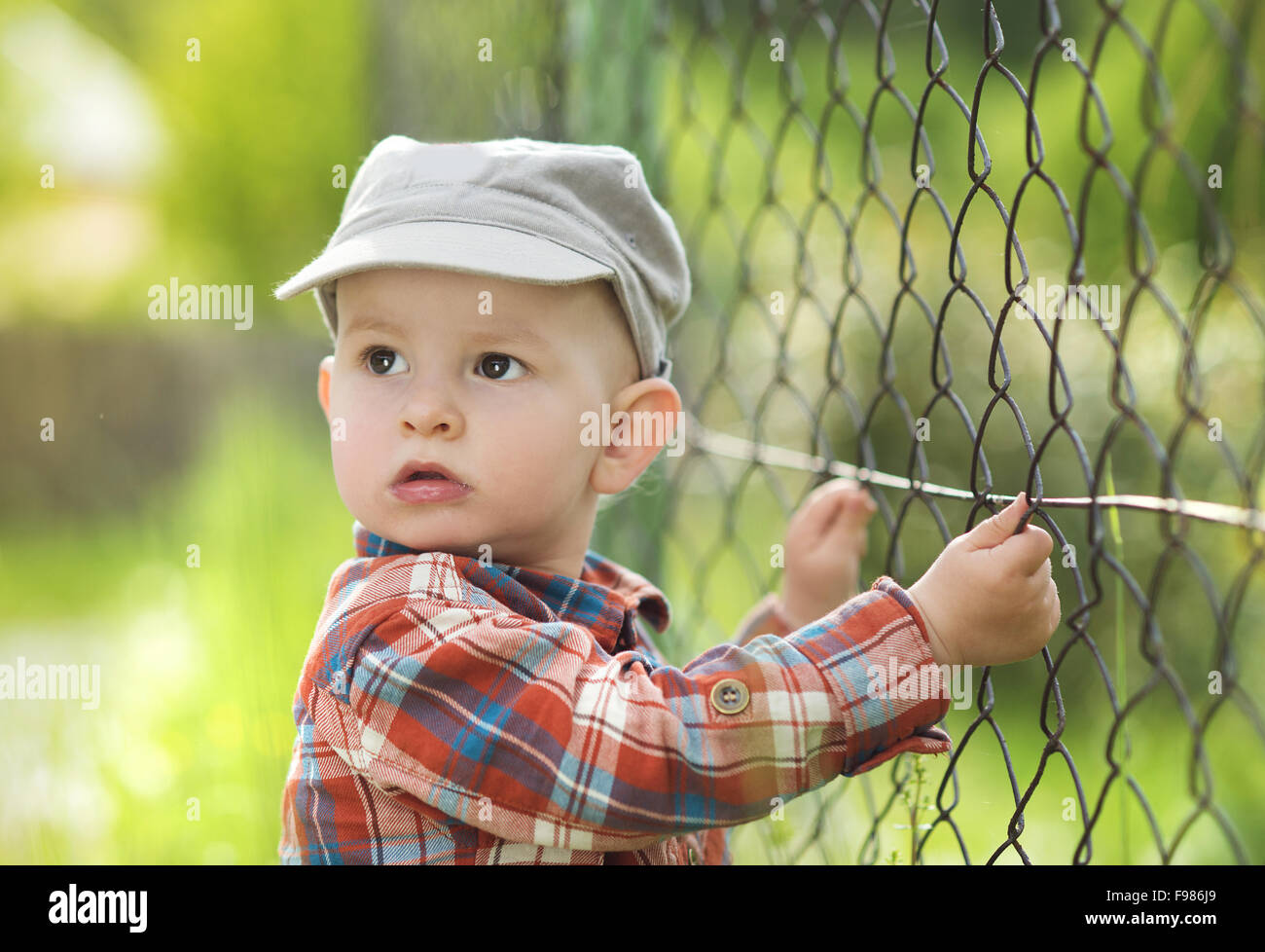 Cute little baby boy à la clôture par Banque D'Images