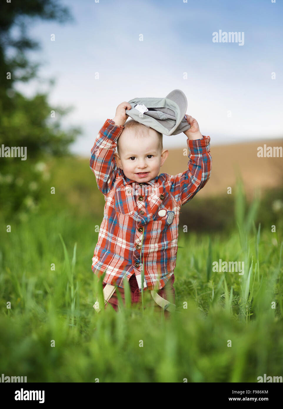 Cute little boy playing in green nature Banque D'Images