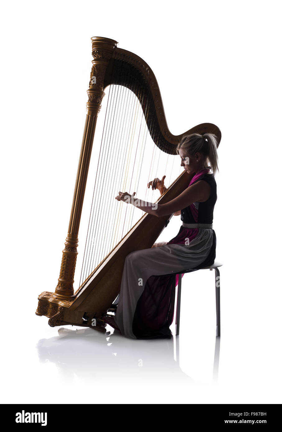 Silhouette de femme élégante robe en jouant de la harpe, isolé sur fond blanc Banque D'Images