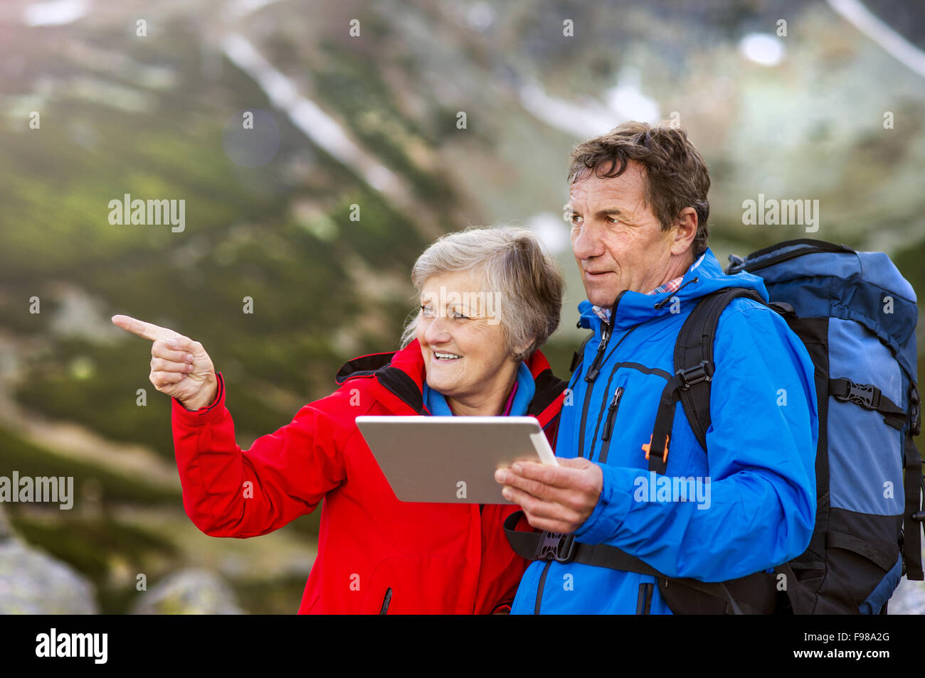 Couple Senior randonnées en utilisant app voyage ou carte sur tablet au cours de la randonnée. Banque D'Images