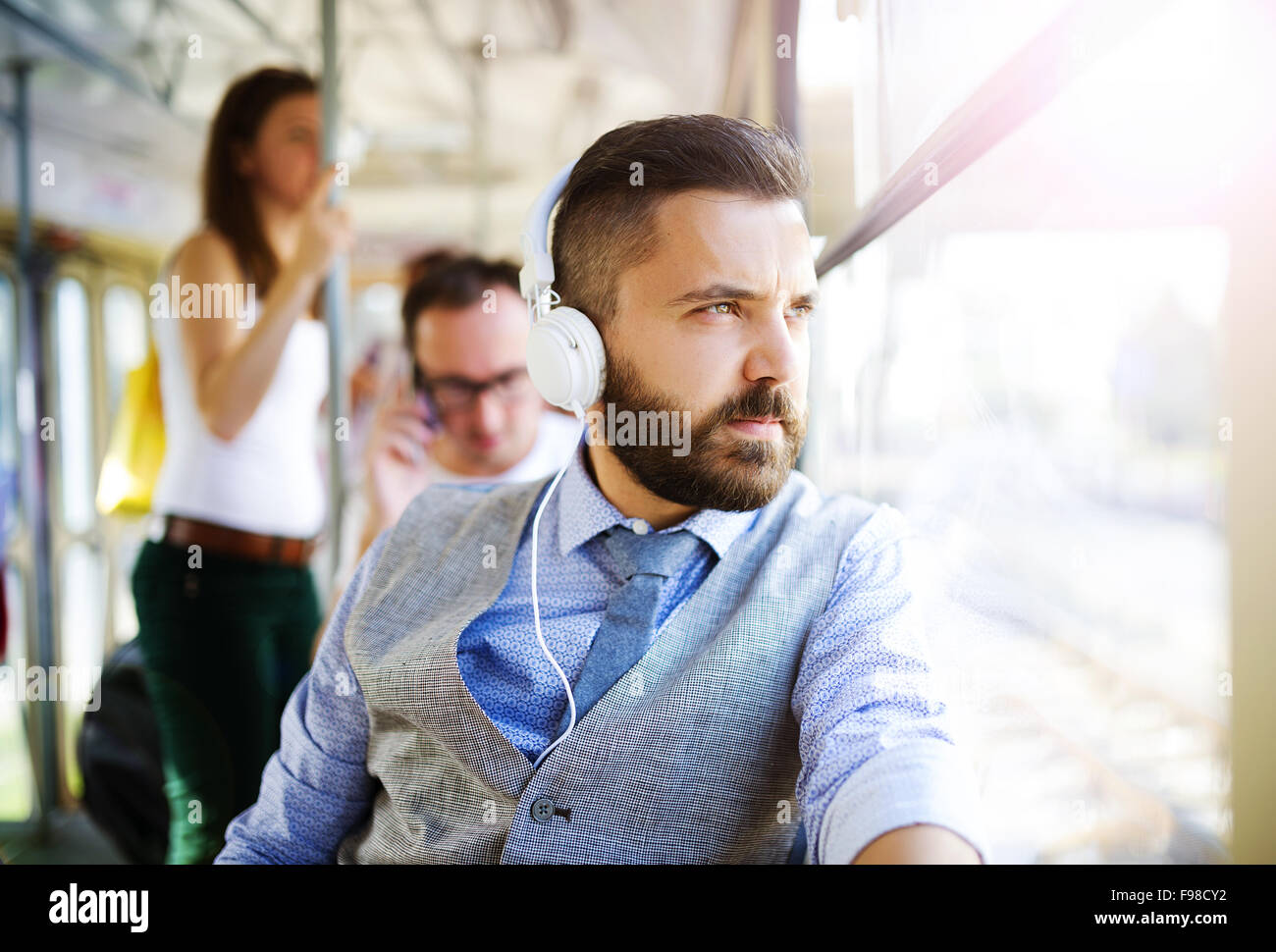 Beau hipster homme moderne avec un casque voyager en tram en ville Banque D'Images