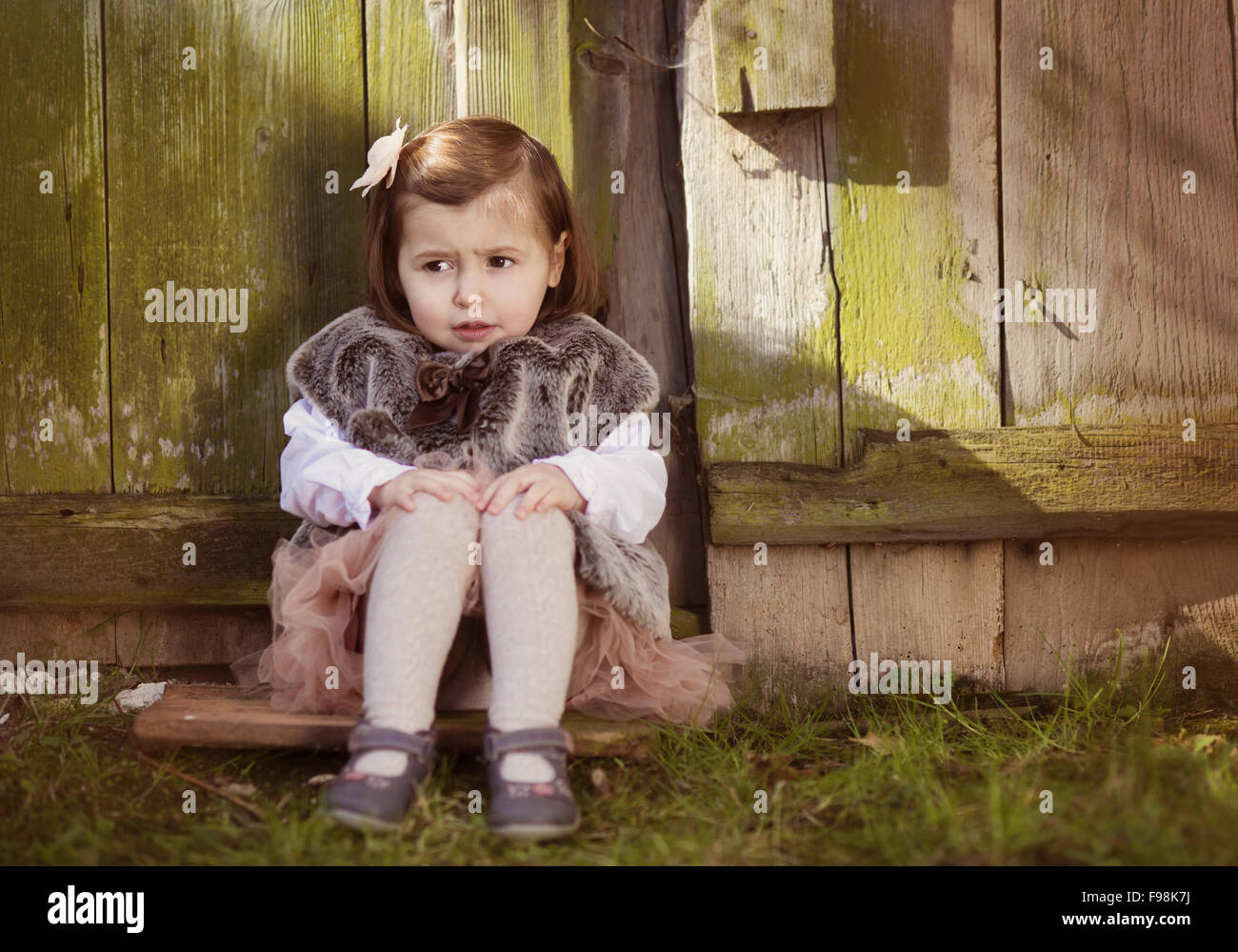 Portrait d'une mignonne petite fille assise sur le vieux toit haut Banque D'Images