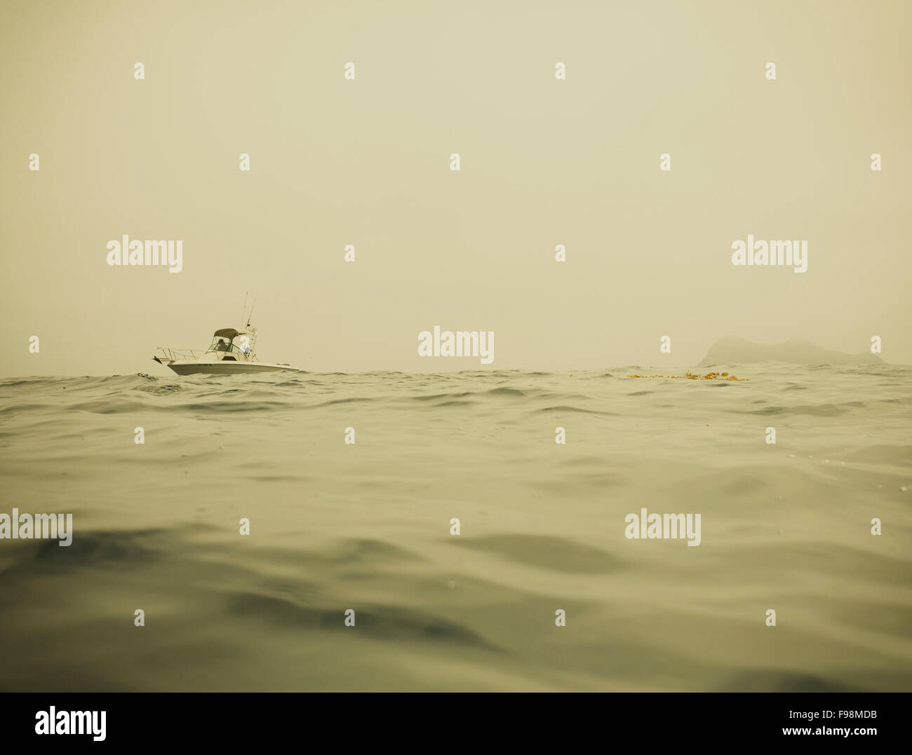 Un petit bateau navigue sur une mer calme. Banque D'Images