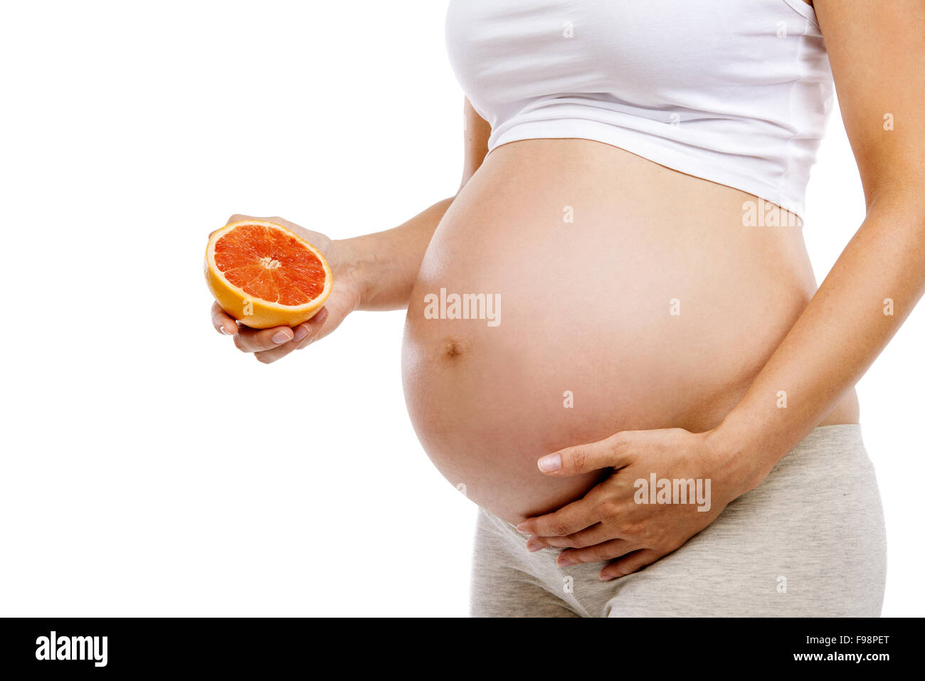 Méconnaissable pregnant woman holding pamplemousse, isolé sur fond blanc Banque D'Images