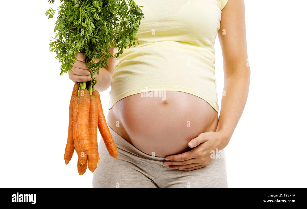 Méconnaissable pregnant woman holding carrots, isolé sur fond blanc Banque D'Images