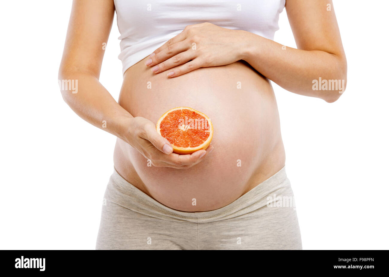 Méconnaissable pregnant woman holding pamplemousse, isolé sur fond blanc Banque D'Images