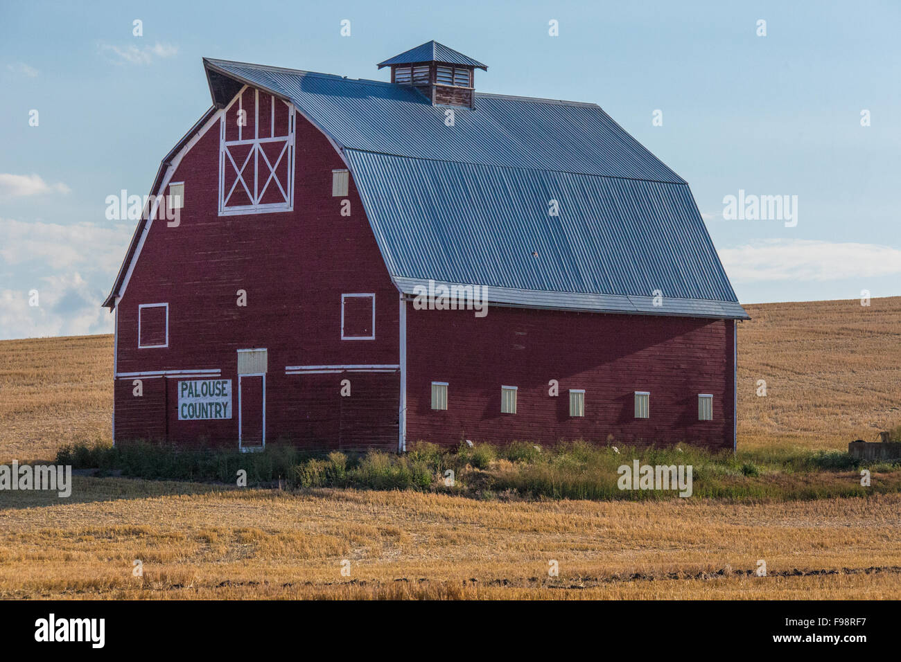 Grange rouge, toit de la hanche en milieu rural de pâturages ; Washington Palouse sign on lit 'grange' Palouse Banque D'Images