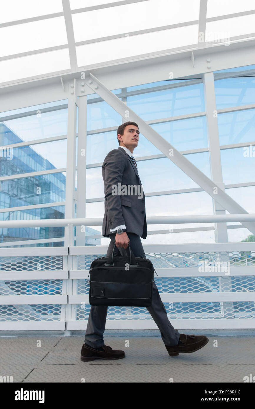 Businessman walking dans l'environnement urbain de l'aéroport ou un immeuble de bureaux Banque D'Images