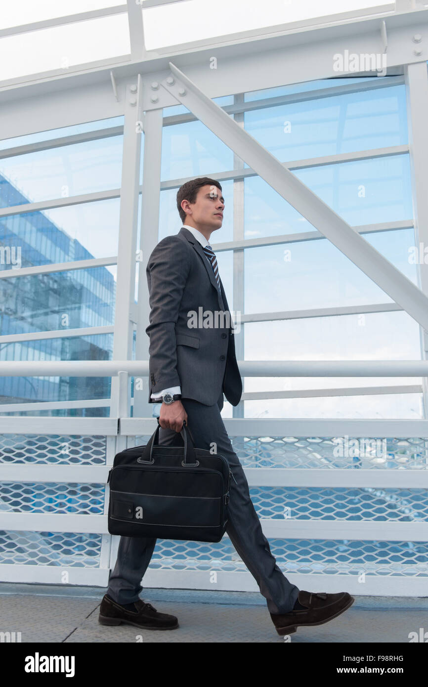 Businessman walking dans l'environnement urbain de l'aéroport ou un immeuble de bureaux Banque D'Images