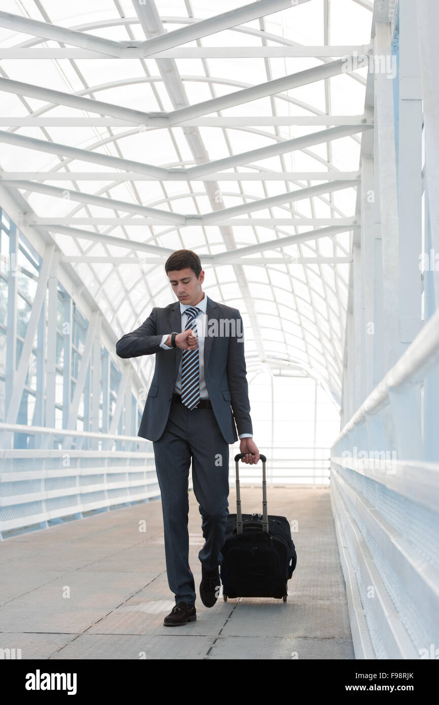 Businessman walking dans l'environnement urbain de l'aéroport avec suitcase Banque D'Images