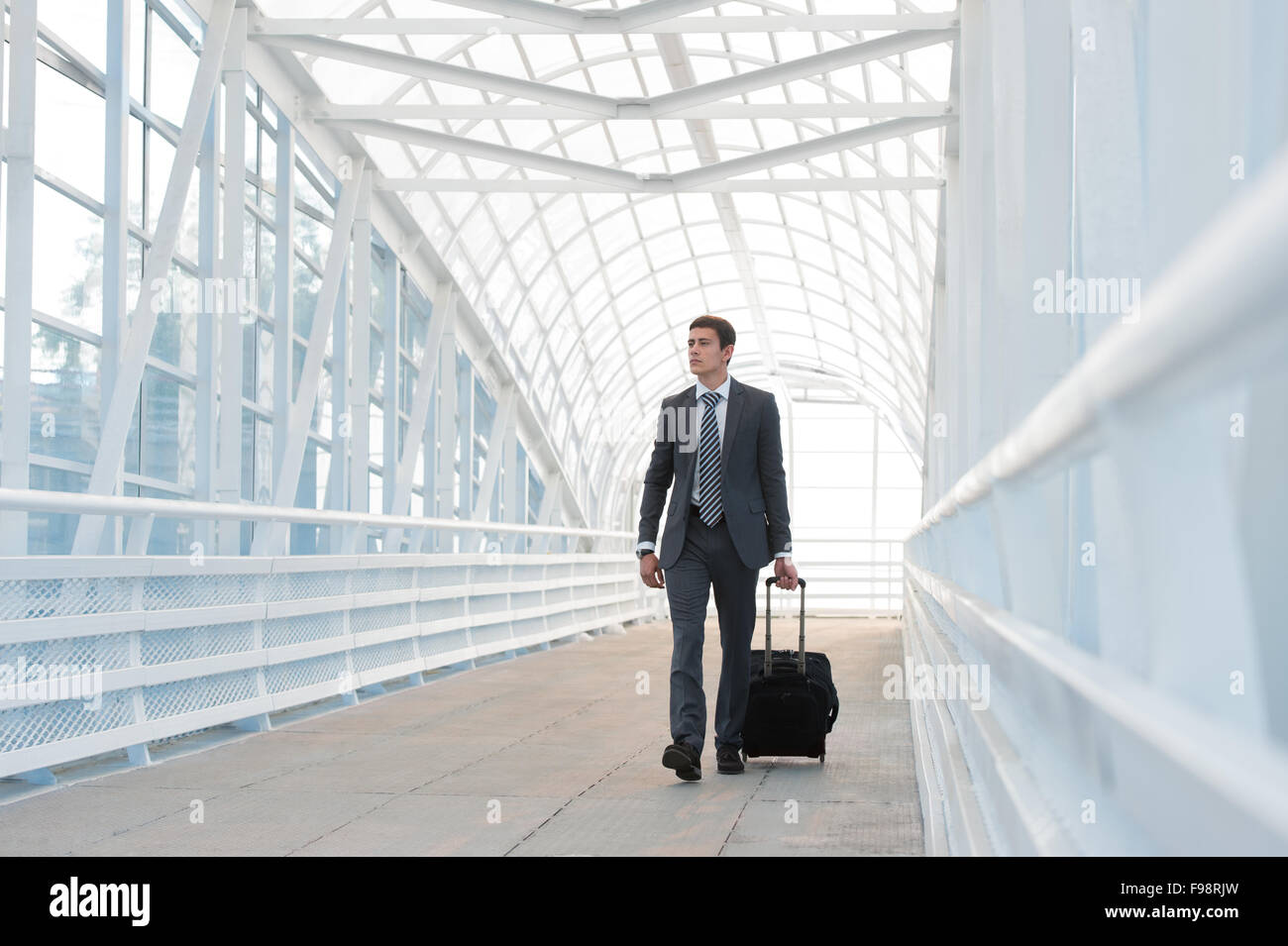 Businessman walking dans l'environnement urbain de l'aéroport avec suitcase Banque D'Images