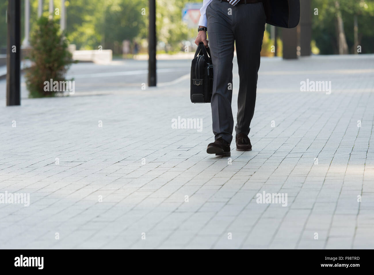 Méconnaissable businessman walking sur la rue près de l'immeuble de bureaux Banque D'Images