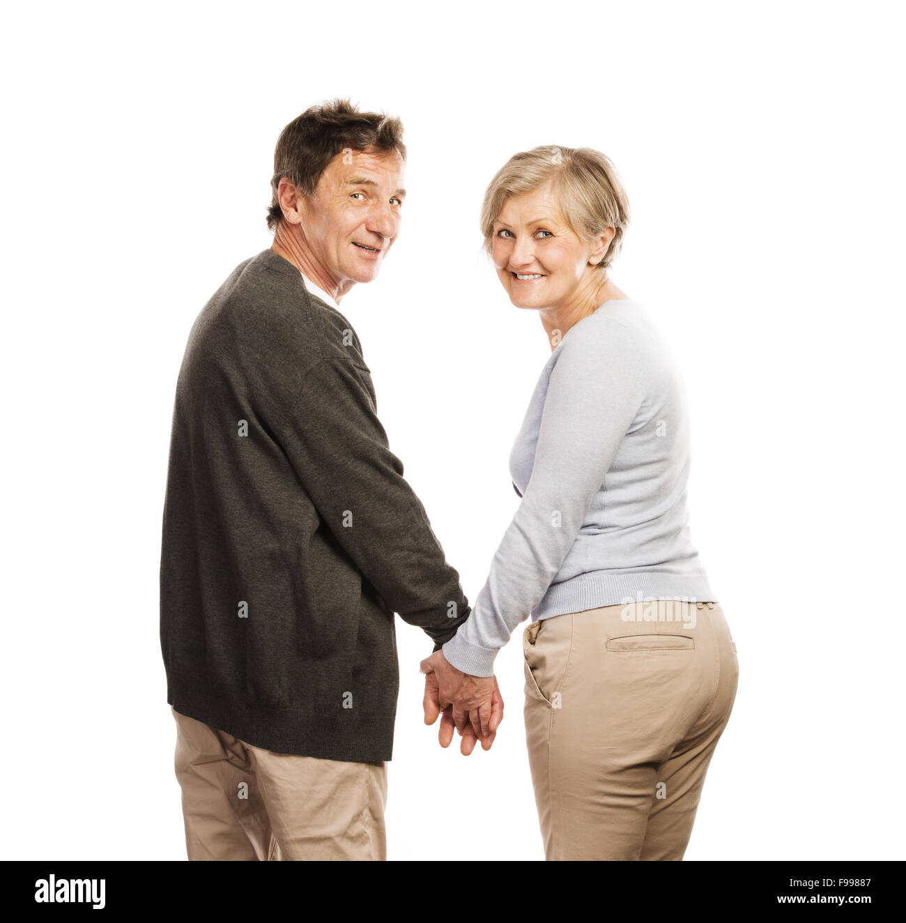 Studio portrait of happy seniors couple holding hands. Isolé sur fond blanc. Banque D'Images