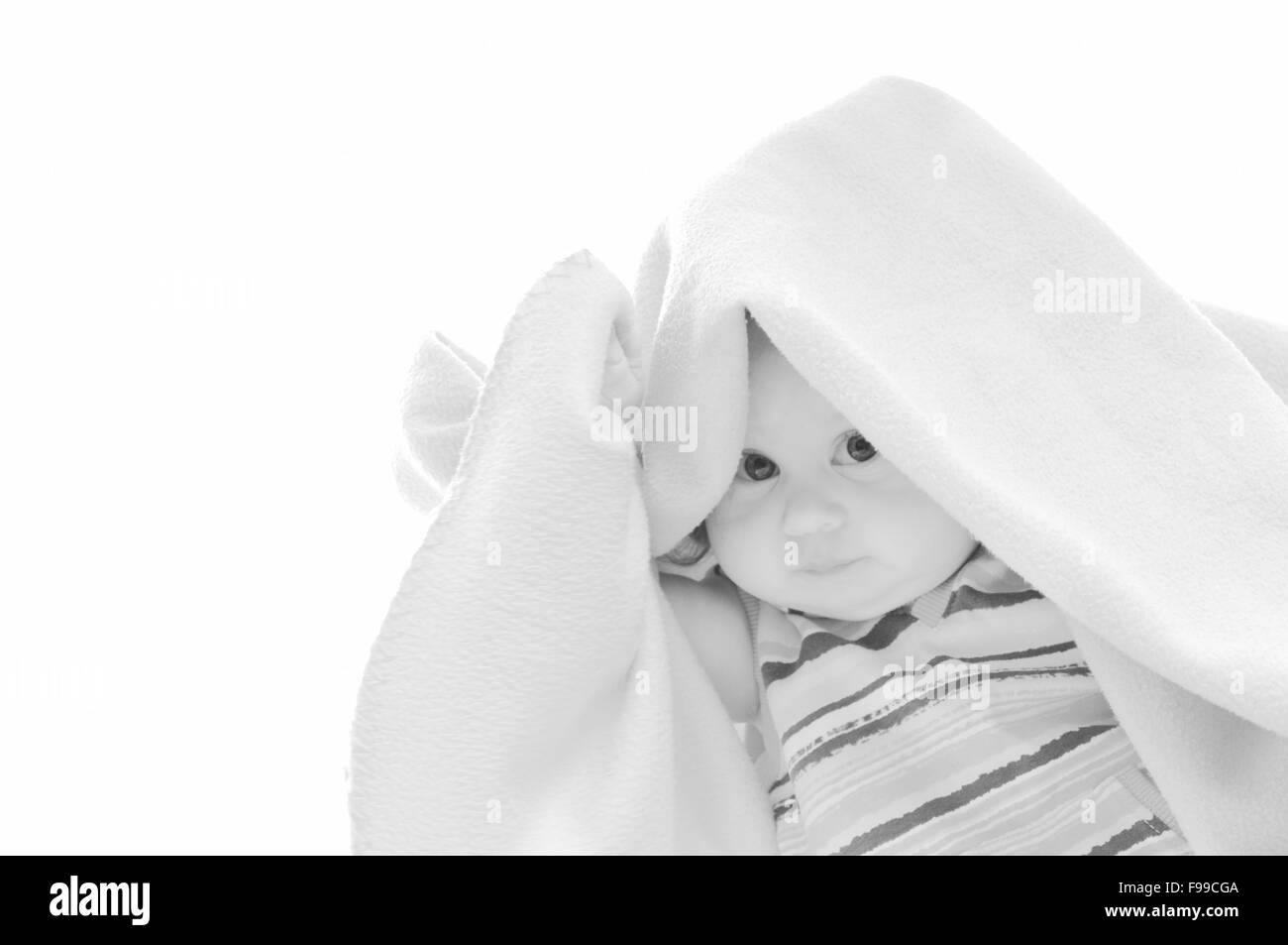 Adorable petit enfant isolé sur blanc sous la seule couverture Banque D'Images