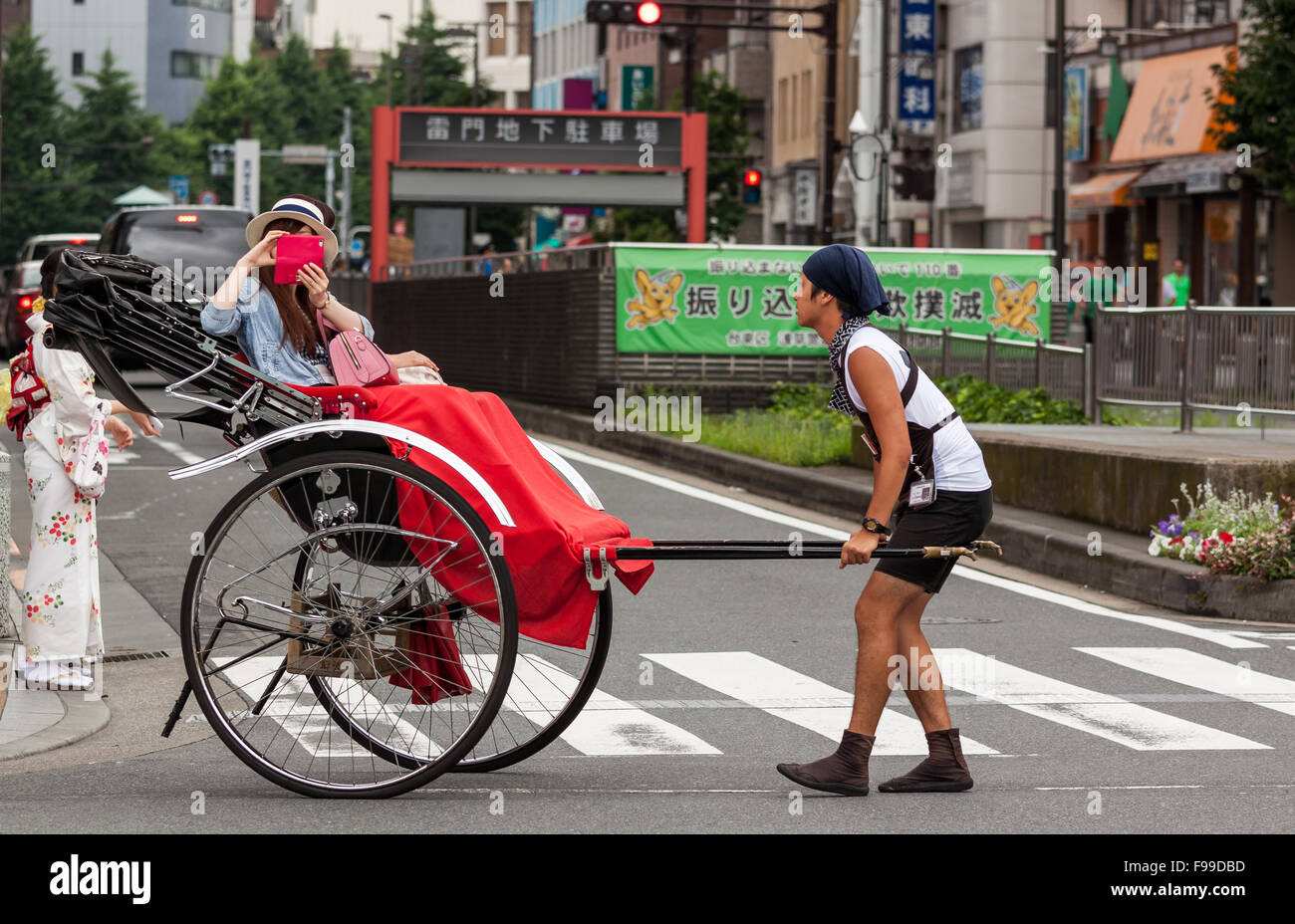 TOKYO, JAPON - 27 juin 2015 : panoramique tourné de touristes à cheval dans le pousse-pousse traditionnel quartier d'Asakusa à Tokyo, Japon. Banque D'Images