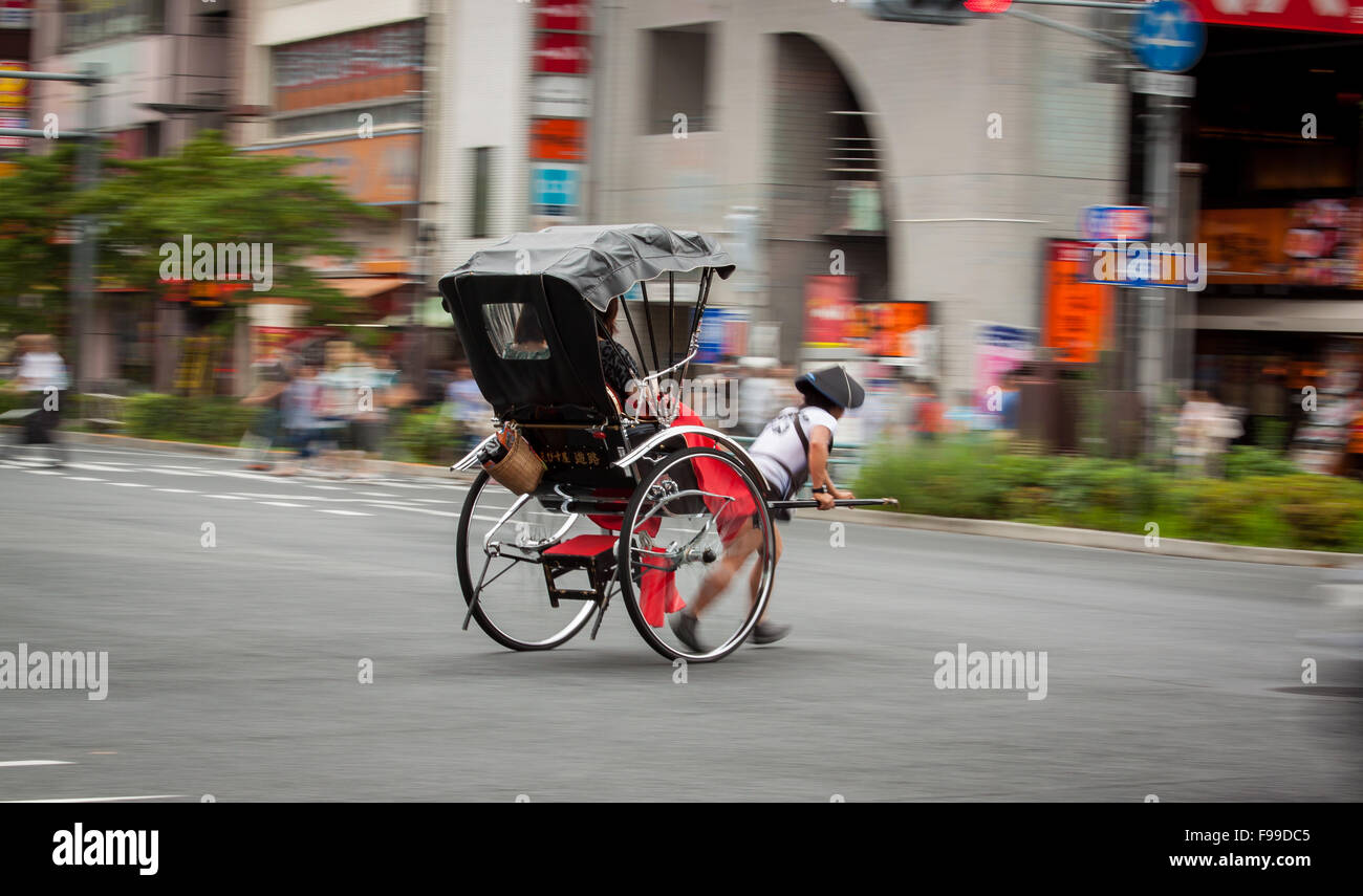 TOKYO, JAPON - 27 juin 2015 : panoramique tourné de touristes à cheval dans le pousse-pousse traditionnel quartier d'Asakusa à Tokyo, Japon. Banque D'Images