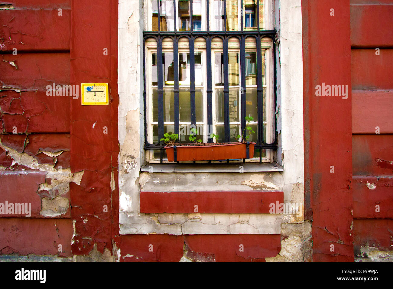 Vieille maison rouge avec une fenêtre grillée Banque D'Images